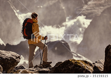 Hiker hiking with backpack looking at waterfall 35159315