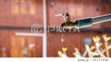 An old water faucet in rural village droping water 35177490