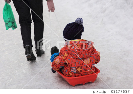 雪道で橇にのり引っ張ってもらう幼児の後ろ姿 雪道で橇にのり引っ張ってもらう幼児の後ろ姿 35177657