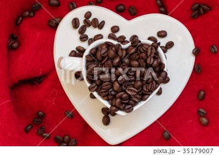 Heart shaped cup with coffee beans on red 35179007