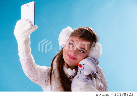 Woman with little snowman taking selfie photo. Woman with little snowman taking selfie photo. 35179322