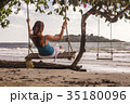 Woman on swings at the seashore 35180096