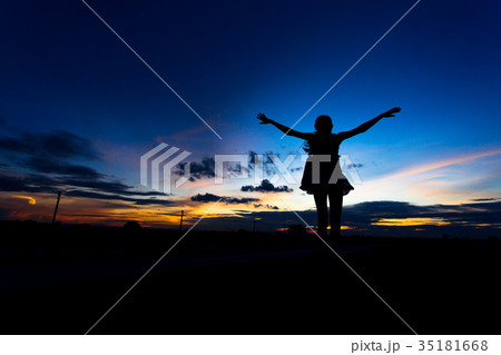 Silhouette of woman posing at sunset or sunrise Silhouette of woman posing at sunset or sunrise 35181668