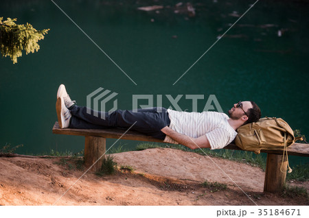 Man Relaxing Outside. Wearing a white T shirt Man Relaxing Outside. Wearing a white T shirt 35184671