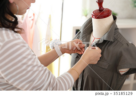 出来上がった服のチェックをするデザイナー 35185129