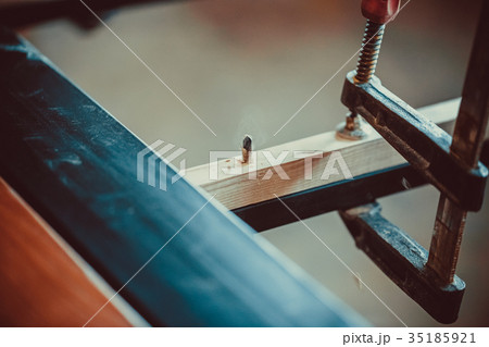 Craftsman using clamps fixate two pieces of wood Craftsman using clamps fixate two pieces of wood 35185921
