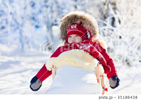 Sled and snow fun for kids. Baby sledding in park. Sled and snow fun for kids. Baby sledding in park. 35186438