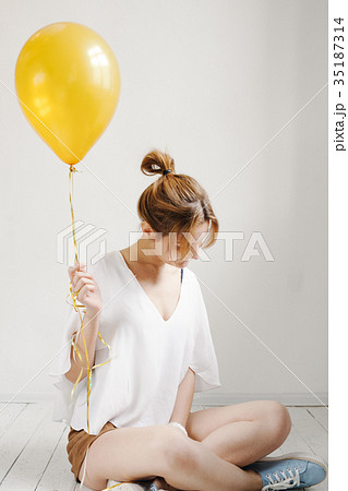 cute girl smiling and playing with yellow balloons cute girl smiling and playing with yellow balloons 35187314