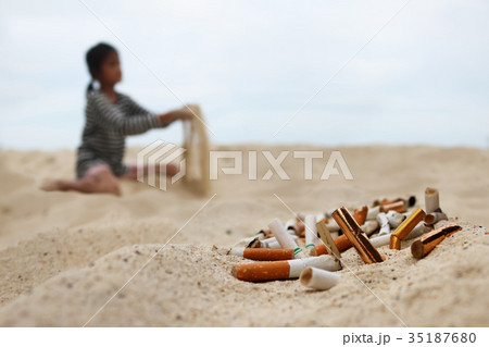 Cigarette and tobacco ashtray on the beach 35187680