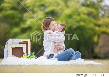 赤ちゃんにキスする母親の写真素材