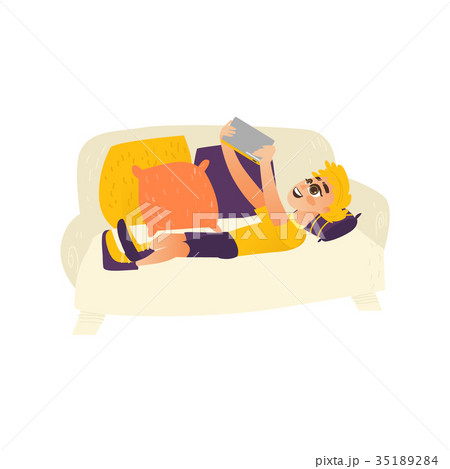 Teenage boy lying on sofa, using tablet gadget Teenage boy lying on sofa, using tablet gadget 35189284
