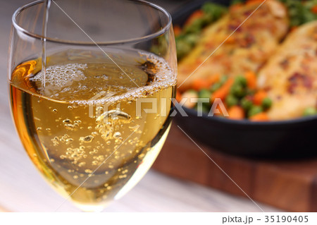 Pouring white wine into glass Pouring white wine into glass 35190405