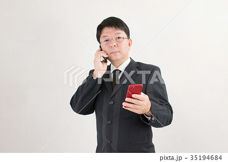 スマホとガラケーを持つビジネスマン、中年男性 35194684