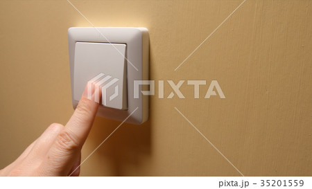 Human hand turn off a power button on a yellow wal Human hand turn off a power button on a yellow wal 35201559