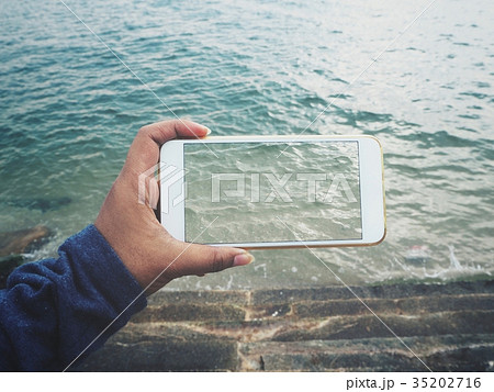 Taking a photo of beach with smart phone 35202716