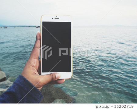 Woman using smart phone on the beach Woman using smart phone on the beach 35202718