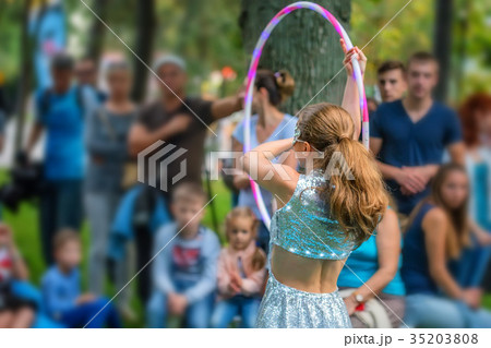 Girl in beautiful dress performs with hula hoops Girl in beautiful dress performs with hula hoops 35203808