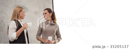 Two young girlfriend sitting in modern coffee shop Two young girlfriend sitting in modern coffee shop 35205137