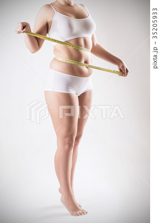 Overweight woman measuring her fat belly. 35205933