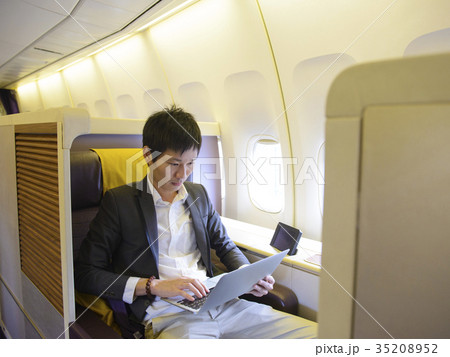 Asian businessman using laptop on first class airp Asian businessman using laptop on first class airp 35208952