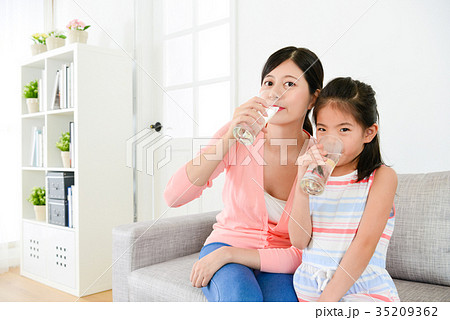 young little daughter with mother sitting on sofa 35209362