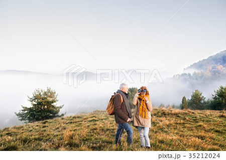 Senior couple on a walk in an autumn nature. 35212024