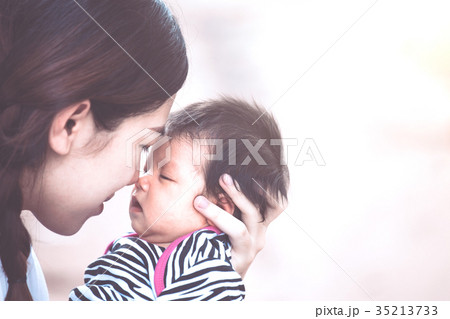 mother hugging and kissing her newborn baby girl mother hugging and kissing her newborn baby girl 35213733