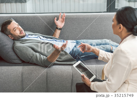 Bewildered man visiting female psychologist 35215749