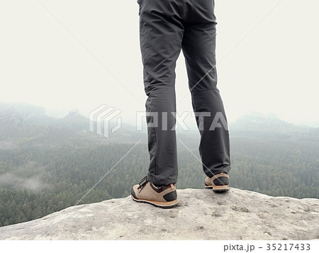Detail of  hiker legs in black orange hiking boots 35217433