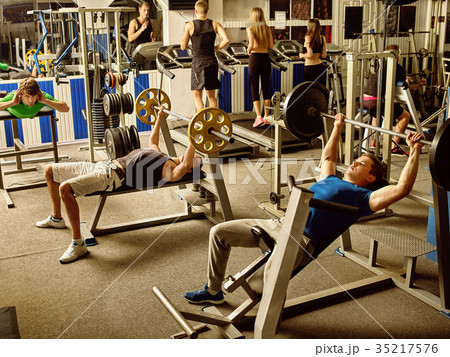 Friends man and women running on treadmil . Friends man and women running on treadmil . 35217576