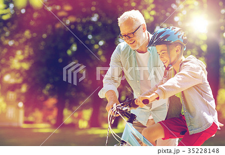 grandfather and boy with bicycle at summer park grandfather and boy with bicycle at summer park 35228148