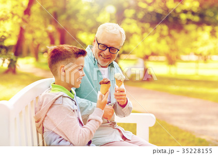 old man and boy eating ice cream at summer park old man and boy eating ice cream at summer park 35228155