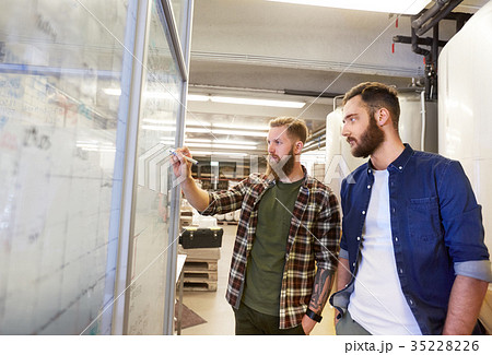 men writing on whiteboard at brewery or beer plant 35228226