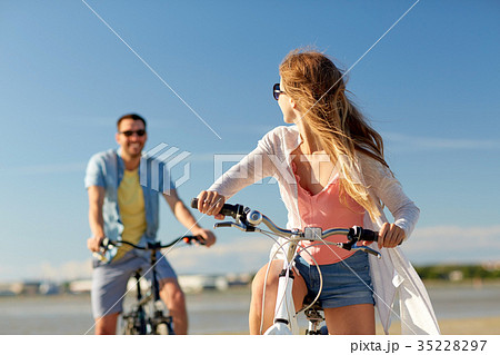 happy young couple riding bicycles at seaside happy young couple riding bicycles at seaside 35228297
