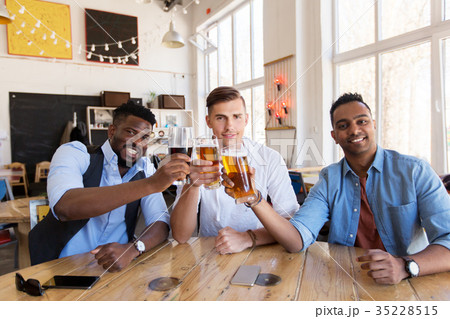 happy male friends drinking beer at bar or pub happy male friends drinking beer at bar or pub 35228515