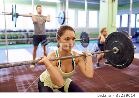 group of people training with barbells in gym 35229014