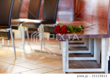 red roses on bench at funeral in church 35229833