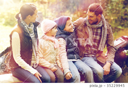 happy family sitting on bench and talking at camp 35229945
