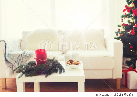 sofa, table and christmas tree with gifts at home 35230035