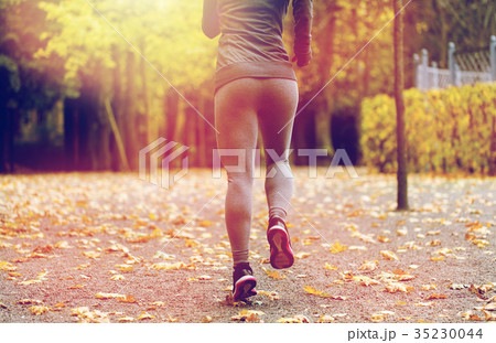 close up of young woman running in autumn park 35230044
