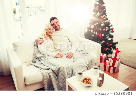 happy couple at home with christmas tree happy couple at home with christmas tree 35230901