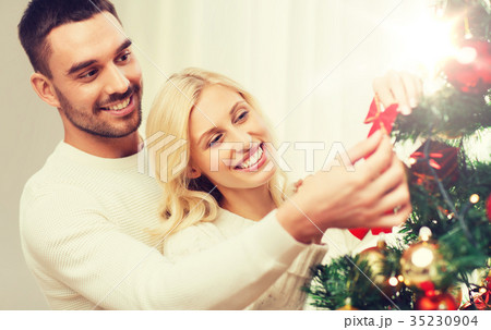 happy couple decorating christmas tree at home 35230904