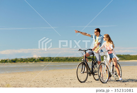 happy young couple riding bicycles at seaside happy young couple riding bicycles at seaside 35231081