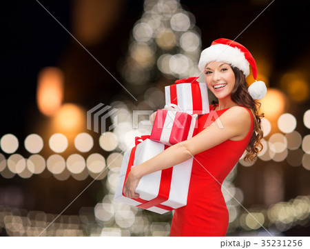 smiling woman in santa hat with gift boxes 35231256
