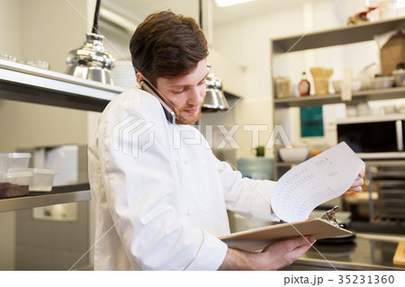 chef cook calling on smartphone at restaurant kitchen 35231360