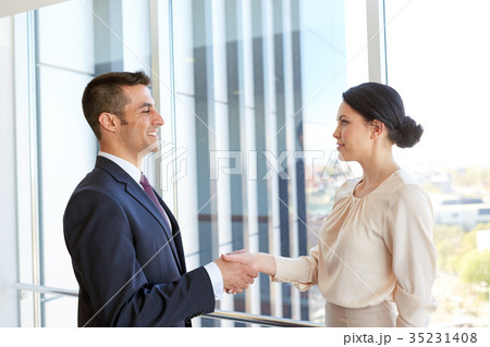 smiling business people shaking hands at office smiling business people shaking hands at office 35231408