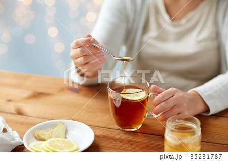 close up of ill woman drinking tea with lemon 35231787