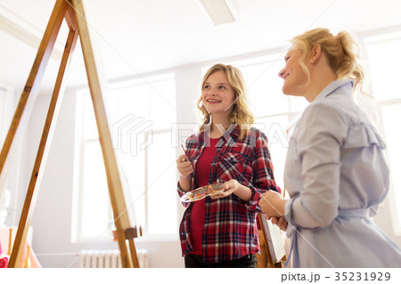 artists discussing painting on easel at art school 35231929
