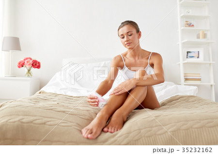 woman with epilator removing hair on legs at home woman with epilator removing hair on legs at home 35232162