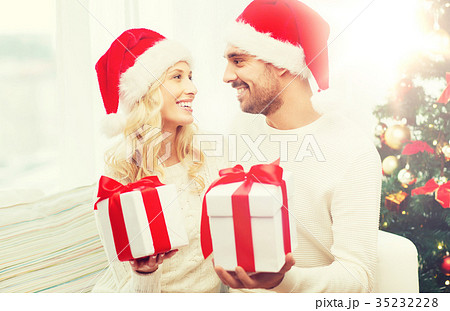happy couple at home exchanging christmas gifts happy couple at home exchanging christmas gifts 35232228